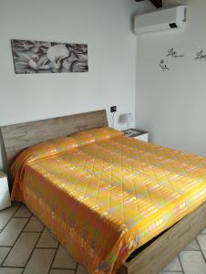 1 cama con edredón naranja en una habitación en Malpensa Milano intero appartamento, en Cardano al Campo