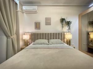 een slaapkamer met een groot bed met 2 lampen bij Fterna Apartment in Perea