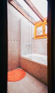 baño con bañera y ventana en Sunny en Villa La Angostura