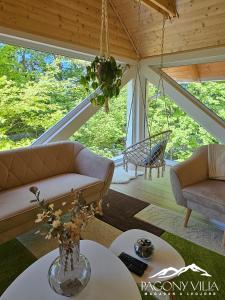 a living room with a couch and a table at Pagony Villa in Galyatető