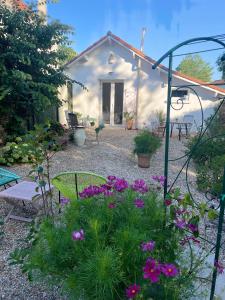 a garden with purple flowers in front of a house at La Petite Maison in Corme-Écluse +20 photos