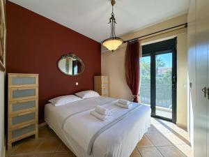 una camera da letto con un letto grande e uno specchio di Luxury Seaside Apt In Pefkochori Featuring Pool a Pefkohori Altre 16 foto