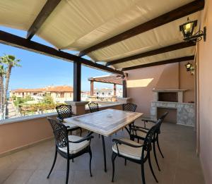 una sala da pranzo con tavolo e sedie su un balcone di Luxury Seaside Apt In Pefkochori Featuring Pool a Pefkohori