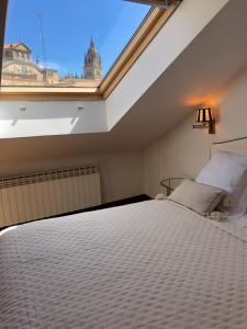 a bedroom with a bed with a large window at Dúplex Sierpes centro parking opcional in Salamanca