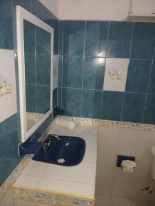 a bathroom with a blue sink and a toilet at La Casa Naranja en Holbox in Holbox Island