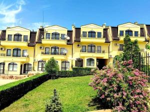 a large yellow building with a yard in front of it at Apartament Morela in Sunny Beach
