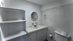 a white bathroom with a sink and a mirror at Andros Waterside Retreat in Deep Creek +56 photos