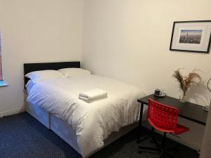 考文垂的住宿－ChaRloHub 01，一间卧室配有一张带红色椅子的床和一张书桌