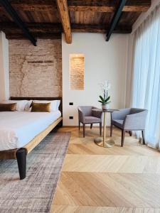 1 dormitorio con 1 cama, mesa y sillas en Palazzo CarpeDiem-Prato della Valle, en Padua