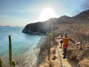 a man and a woman walking down a path near the water at Casa Mi Valle Loft in Santa Marta