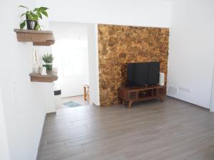 a living room with a flat screen tv on a wall at Casal Regina in Sesimbra