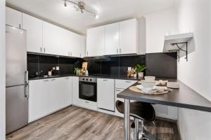 a white kitchen with white cabinets and a table at Perfect getaway 7 min to centrum in Bergen