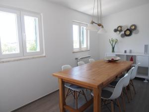 a dining room with a wooden table and chairs at Casal Regina in Sesimbra