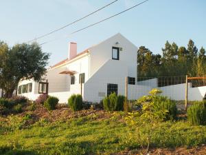 une maison blanche avec une clôture dans l'établissement Casal Regina, à Sesimbra