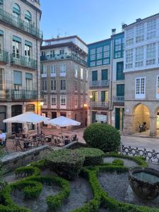 un patio con mesas y sombrillas frente a los edificios en Apartamento Cervantes, en Ourense