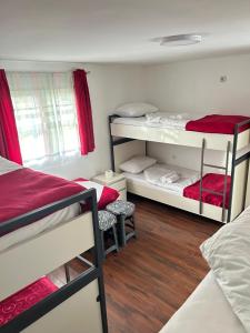 a dorm room with two bunk beds and red curtains at Sneza in Podgorica