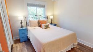 a bedroom with a bed with two night stands and a window at 2nd Avenue - Mid Island by Tybee Vacation Rentals in Tybee Island
