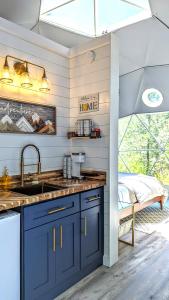 una cocina con armarios azules y fregadero en Natures Dome @SmokyMountain, en Sylva