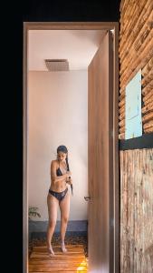 a woman in a bikini standing in a doorway at Cabaña 25km de Medellín, Benevento Glamping in Girardota