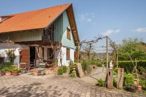 ein Haus mit einem grünen Dach und einer Ziegelsteinfahrt in der Unterkunft Obst- Ferienhof Ragg in Immenstaad am Bodensee