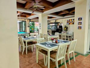 a dining room with tables and chairs and a pool at Patong Central Residence & Apartment in Patong Beach