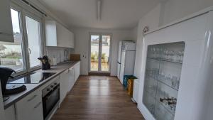 a kitchen with white appliances and a wooden floor at Coastal Breeze Apartment - Equihen-Plage in Équihen-Plage
