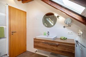 ein Badezimmer mit Waschbecken und Spiegel in der Unterkunft Obst- Ferienhof Ragg in Immenstaad am Bodensee + 37 Fotos