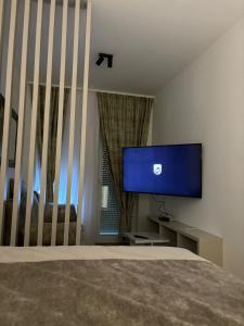 Schlafzimmer mit einem Flachbild-TV und einem Bett in der Unterkunft Studio apartman M in Posušje