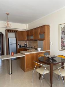 eine Küche mit Holzschränken und einem Tisch mit Stühlen in der Unterkunft Orsalia's Apartment in Neapolis