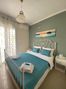 a bedroom with a bed with blue and white sheets at Orsalia's Apartment in Neapoli Voion