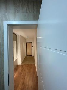 einen Flur mit weißen Wänden und Holzböden in der Unterkunft Studio apartman M in Posušje