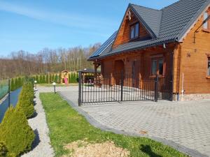 une clôture en face d'une maison avec une aire de jeux dans l'établissement Dom u Julii nad Strwiążem -Bieszczady, à Ustrzyki Dolne
