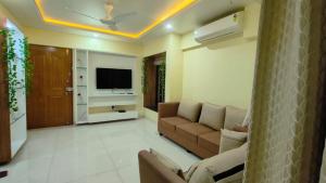 a living room with a couch and a television at The ten - 2 rooms in 3bhk apartment in Pune