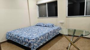 um pequeno quarto com uma cama e uma mesa de vidro em The ten - 2 rooms in 3bhk apartment em Pune