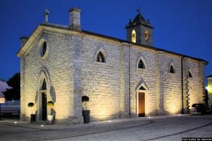 a church with a clock tower on top of it at Casa Verdi in Telti