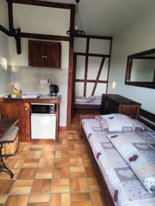 a room with two beds and a kitchen with a stove at Pokoje Gościnne Skalnik in Kostrzyn nad Odrą