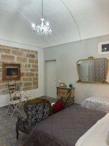 a bedroom with a bed and a chair and a mirror at Le Alcove in Cinisi