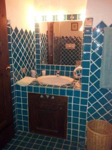 ein blau gefliestes Bad mit einem Waschbecken und einem Spiegel in der Unterkunft Apartment Alba in Porto Cervo