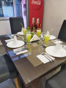 a wooden table with plates and glasses and drinks at Apartman in Vogošća