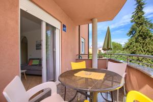 a balcony with a table and chairs on a balcony at Green House in Premantura