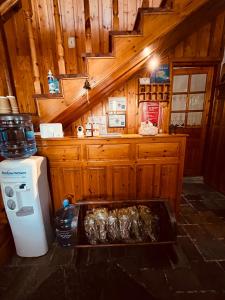 a kitchen with wooden walls and a refrigerator and a table at 9mouses Chasiotis Guest House in Ampelakia