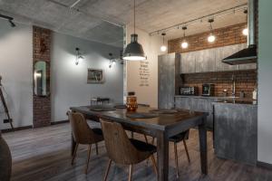 a dining room with a wooden table and chairs at Manto Loft style apartment in Klaipėda