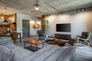 a living room with a couch and a tv at Manto Loft style apartment in Klaipėda