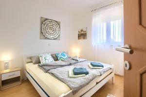 a bedroom with a bed with blue pillows on it at Green House in Premantura