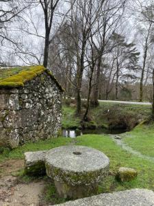 un banco de piedra sentado junto a una pared de piedra en Casa con vistas a Portugal, en Arbo