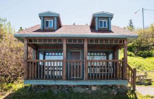 Cabaña de madera con porche y balcón en Auberge Festive Sea Shack en Sainte-Anne-des-Monts
