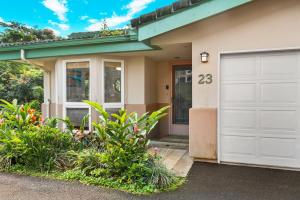 a house with a white garage door at Stunning 3br 3ba Corner Unit Villa of Kamalii, AC, Pool, Hot Tub Unit 23 in Princeville