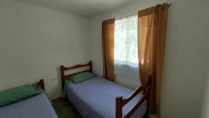two beds in a room with a window at Cabañas Imperio Pisco Elqui in Pisco Elqui