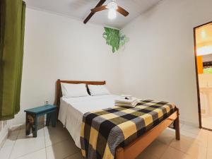 a bedroom with a bed with a checkered blanket at Hospedagem Donalu - Vale do Capão in Palmeiras