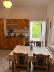 a kitchen with a wooden table with chairs and a dining room at Kiskatona Vendégház in Balatonkenese +34 photos